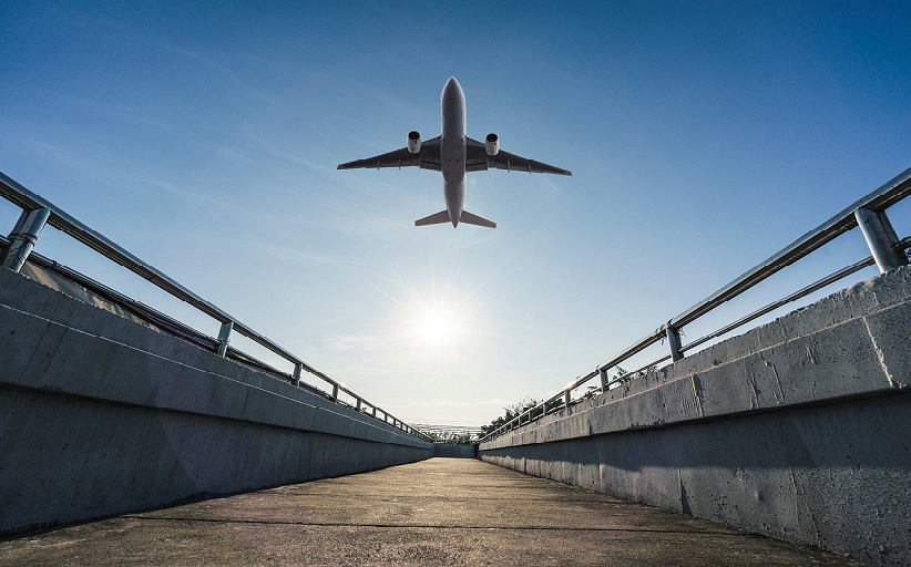 Avión despegando, visto desde un puente. Artículo sobre gestión de tarifas por parte de un gestor de viajes corporativos.
