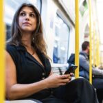 Woman using phone on subway train