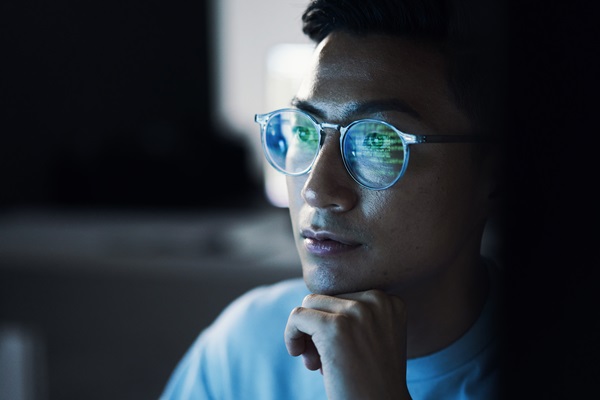 Person with glasses looking at computer screen