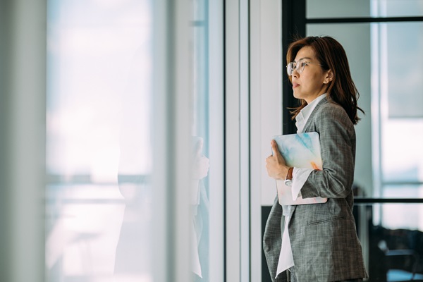 Professional woman in office holding a folder.