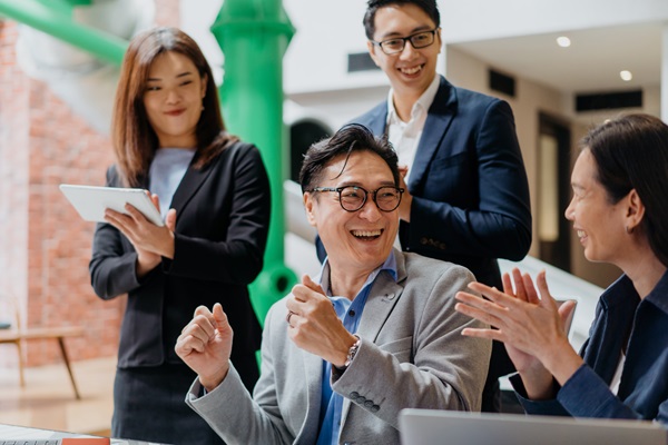 Group of professionals laughing during a meeting.