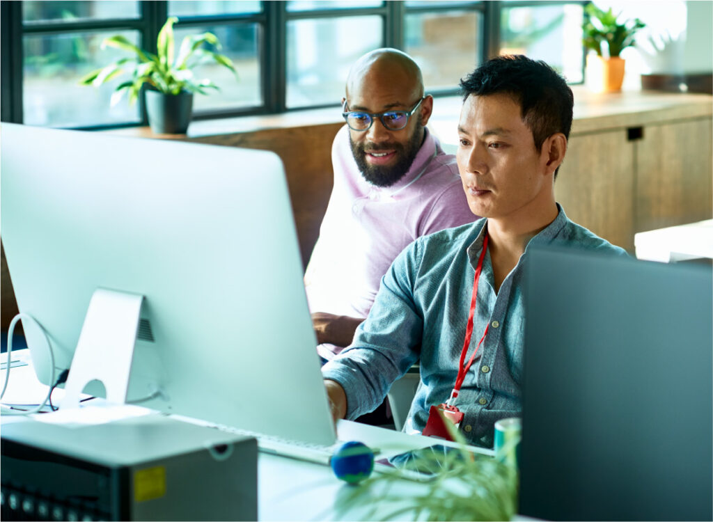 Dos hombres trabajando en un ordenador grande.