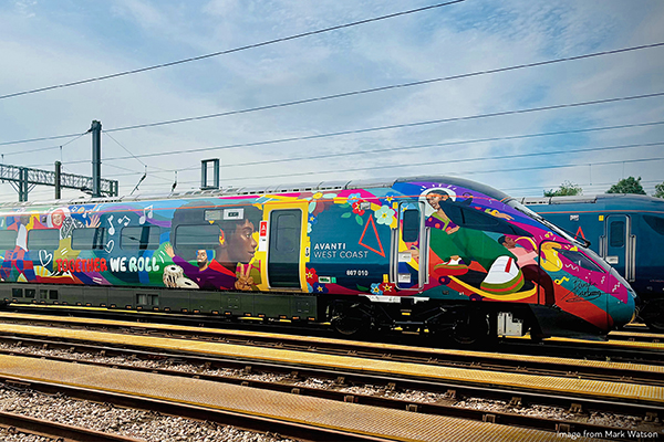 Colorful train with vibrant graphics on tracks.