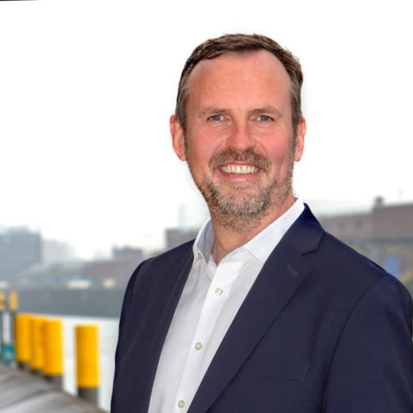 Hombre sonriente con fondo industrial