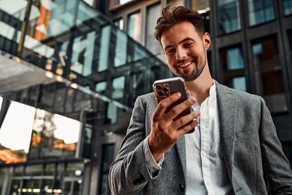 Businessman in office suit using smartphone.