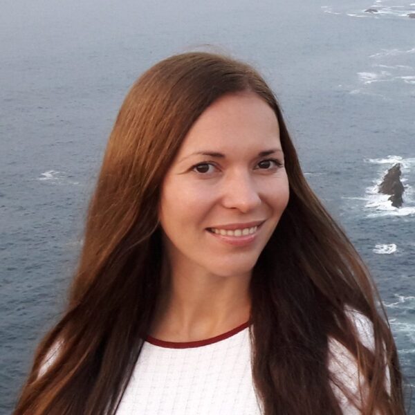 Femme souriante devant la mer et falaises