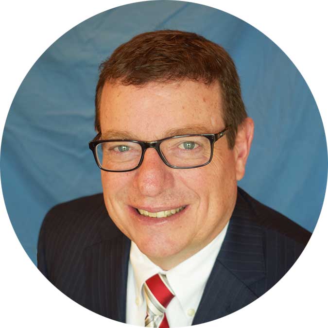 Person smiling in glasses and suit